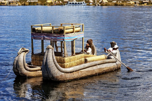 People on a large reed boat on a lake, dressed traditionally, The floating reed islands of the Uros in Lake Titicaca in Peru