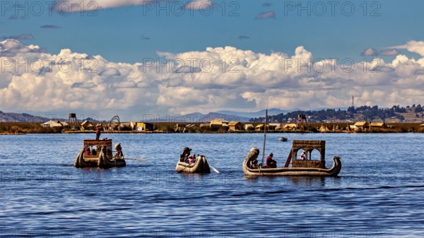 People ride in artfully designed reed boats on a wide lake, The floating reed islands of the Uros in Lake Titicaca in Peru