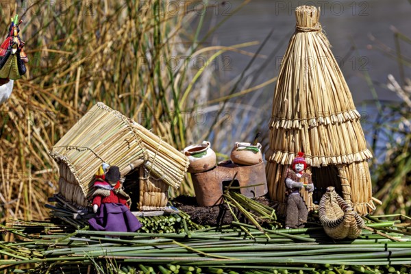 Miniature huts and figures made of straw and clay on a natural support, The floating reed islands of the Uros in Lake Titicaca in Peru