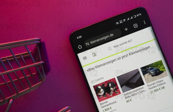 Dhaka, Bangladesh- 23 June 2025: A smartphone displaying the Kleinanzeigen website with a shopping cart is shown on a vibrant background