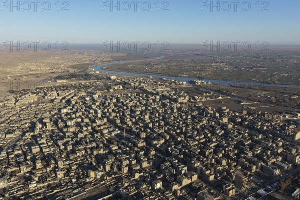 In Deir ez-Zor, Eastern Syria on January 21, 2026, an aerial drone shot captures the city landscape after Syrian Government forces successfully secured control. The deployment follows the withdrawal of SDF (Syrian Democratic Forces) elements as part of the broader strategic shifts and integration agreements in the region. The footage shows the city's infrastructure and the Euphrates River under the new military administration, Deir ez-Zor, Deir ez-Zor, Syria