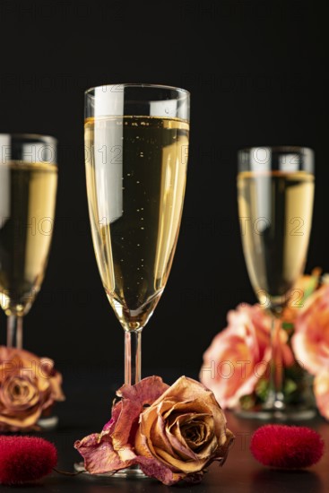 Three glasses with roses and hearts, dark background