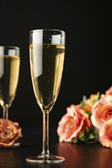 Filled champagne glasses with roses, dark background