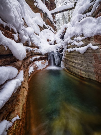 Taugl or Tauglbach flows through the snow-covered and icy red gorge, also Marmorklamm, Bad Vigaun, Tennengau, Salzburg, Austria