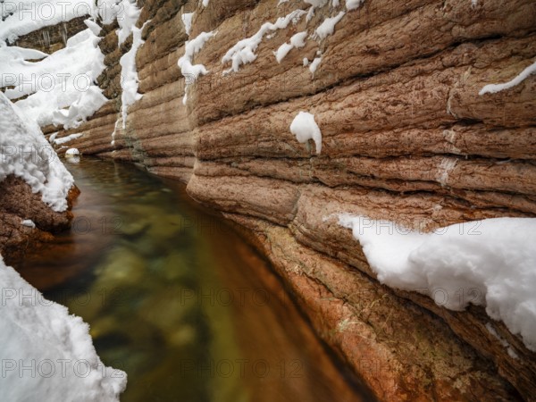 Taugl or Tauglbach flows through the snow-covered and icy red gorge, also Marmorklamm, Bad Vigaun, Tennengau, Salzburg, Austria