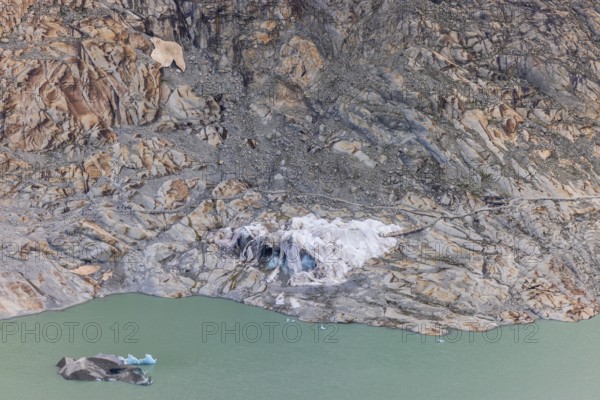 Remains of the Rhone Glacier ice cave covered with protective white geotextile sheets, highlighting climate change and global warming, Oberwald, Goms, Valais Canton, Switzerland