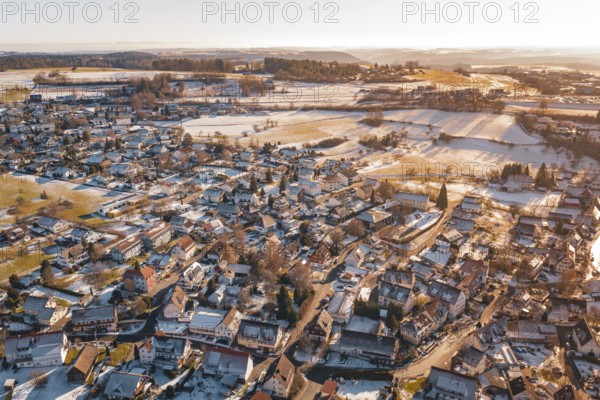 Aerial view of a snowy village with adjacent fields in the soft light of a winter sunset, Hallwangen, Freudenstadt district, Germany