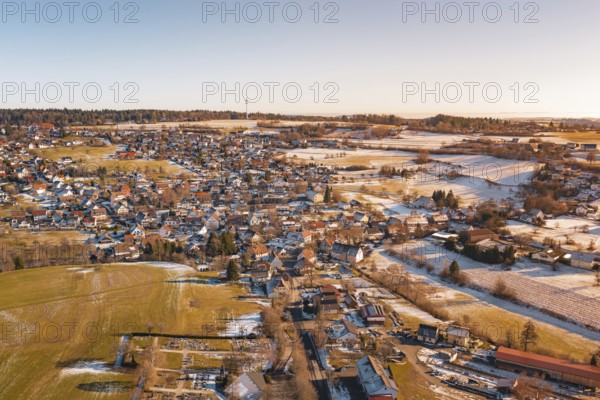 An aerial perspective of a sprawling village with snow-covered fields and settlements under clear skies, Hallwangen, Freudenstadt district, Germany