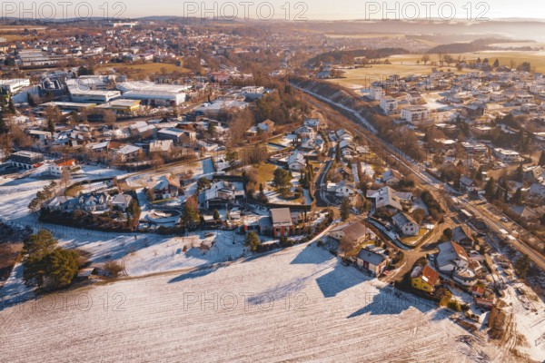 Aerial view of a rural village, partly covered by snow, with roads and trees under clear sky, Hallwangen, Freudenstadt district, Germany