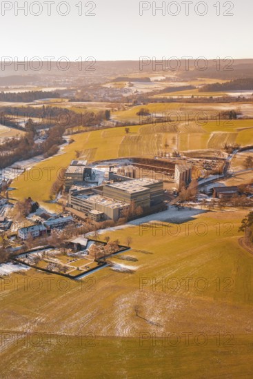 Wintery field landscape with industrial buildings in the distance under clear skies, Hallwangen, Freudenstadt district, Germany