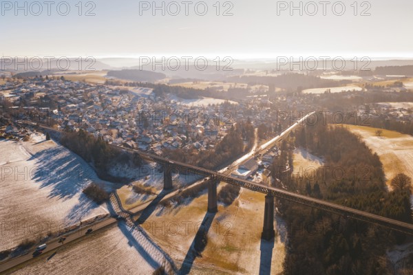 Snowy landscape with bridge and wide view of a village in warm light, Aach, Dornstetten, Freudenstadt district, Germany