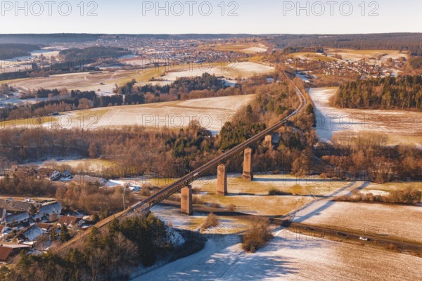 Winter landscape with a railroad bridge across fields and snow-covered hills, Dornstetten, Freudenstadt district, Germany