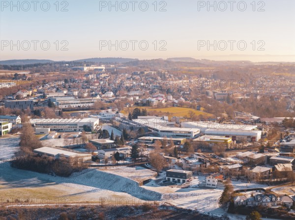 City view in winter with snow-covered fields and buildings under a foggy sky, Dornstetten, Freudenstadt district, Germany