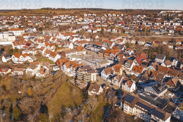 Aerial view of a city with many buildings and red roofs, in a wintry landscape in sunshine, Dornstetten, Freudenstadt district, Germany
