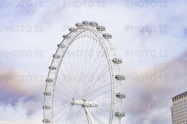 A large Ferris wheel stretches high over an urban backdrop, London Eye, London, United Kingdom