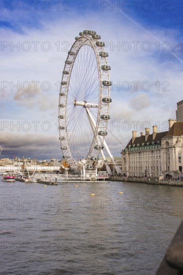 City panorama with a Ferris wheel on a river under clear sky, London Eye, London, United Kingdom