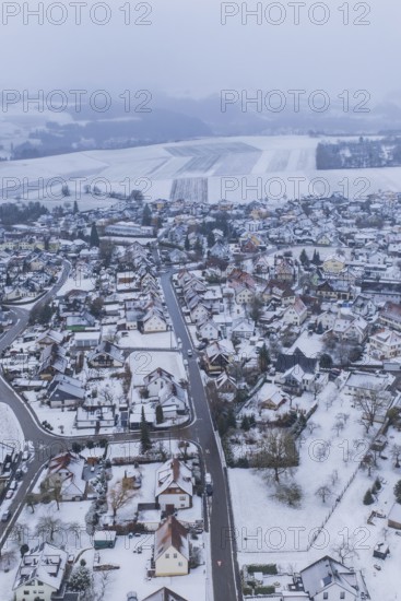 Snowy city landscape with houses and fields under a grey sky, Empfingen, Freudenstadt district, Germany