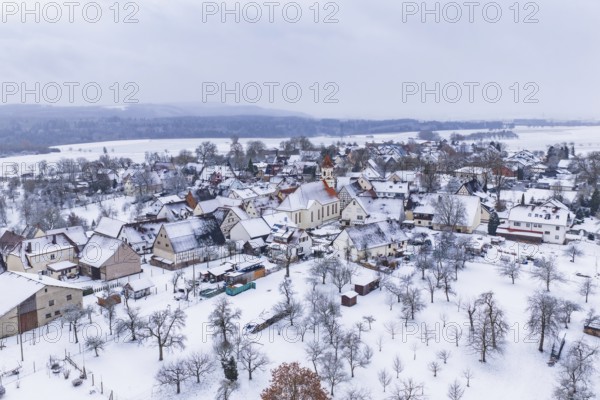 Snowy village with church in the center, surrounded by winter landscape, Wiesenstetten, Freudenstadt district, Germany