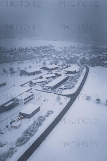 Winter aerial view of a snowy village surrounded by a winding road, Hörschweiler, Freudenstadt district, Germany