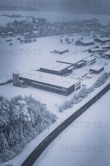 Aerial view of a snowy factory and road with surrounding trees, Hörschweiler, Freudenstadt district, Germany