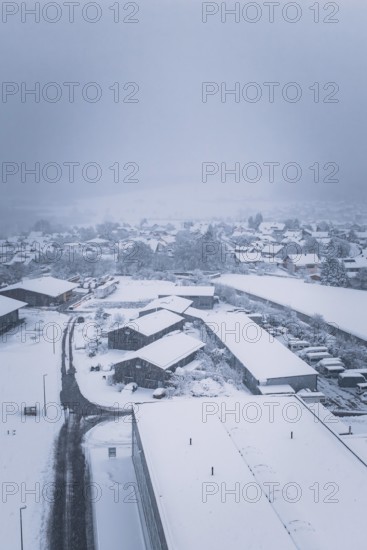 Snowy village landscape with buildings under a cloudy sky, Hörschweiler, Freudenstadt district, Germany