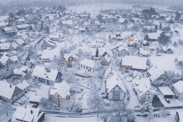 Snowy village with a church wrapped in a cold, peaceful atmosphere, Schopfloch, Freudenstadt district, Germany