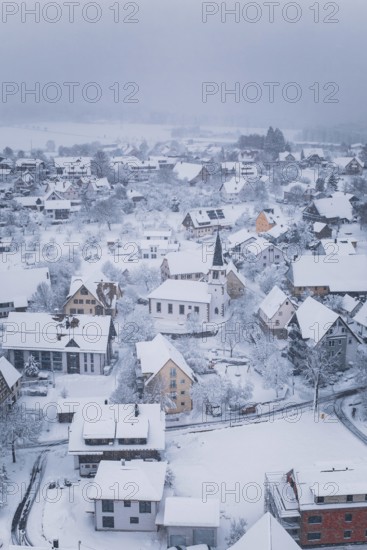 Wintery village with snow-covered roofs and a church in the center, Schopfloch, Freudenstadt district, Germany
