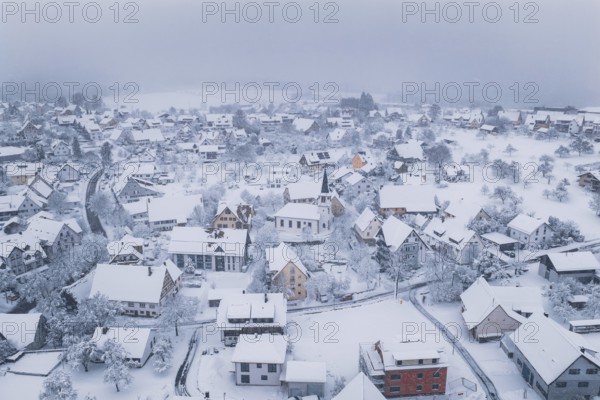 Village in winter with a church and snow-covered roofs in quiet surroundings, Schopfloch, Freudenstadt district, Germany
