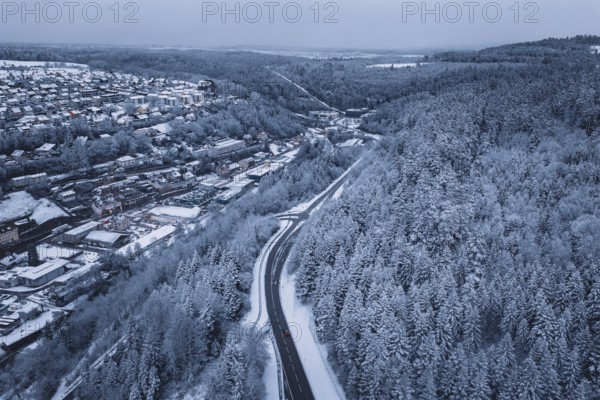 Snowy road between thick forests, wintry driving experience, Altensteig, Calw district, Germany