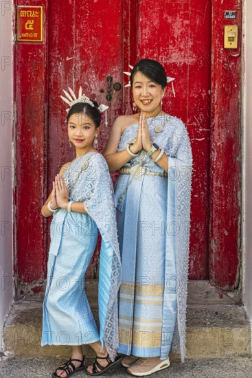 Mother and daughter in traditional clothing present themselves for the photographers, Wat Arun Buddhist temple, Bangkok, Thailand's metropolis, Thailand