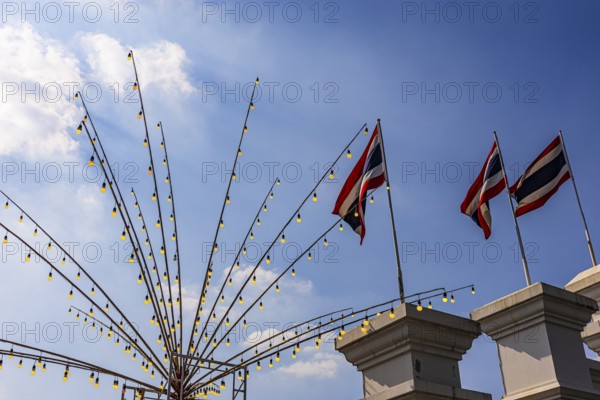 Rods with light bulbs and Thai flags against a blue sky, Bangkok, Thailand's metropolis, Thailand