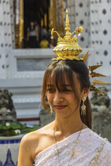 Young woman with traditional headdress, wearing traditional clothing, presenting herself to the photographers, Wat Arun Buddhist temple, Bangkok, Thailand's metropolis, Thailand