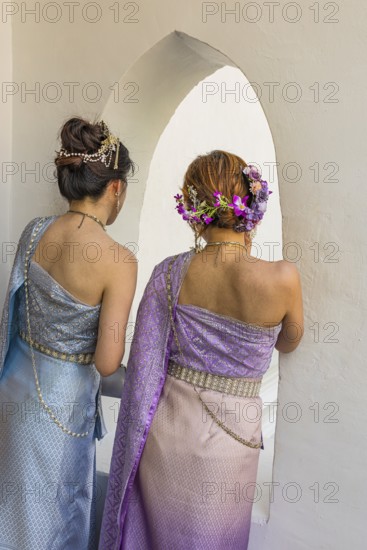 Young woman with traditional headdress, wearing traditional clothing, present themselves for the photographers, Wat Arun Buddhist temple, Bangkok, Thailand's metropolis, Thailand