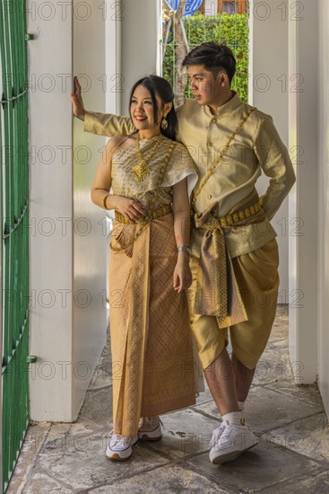 Young woman and young man in traditional clothing present themselves for the photographers, Wat Arun Buddhist temple, Bangkok, Thailand's metropolis, Thailand
