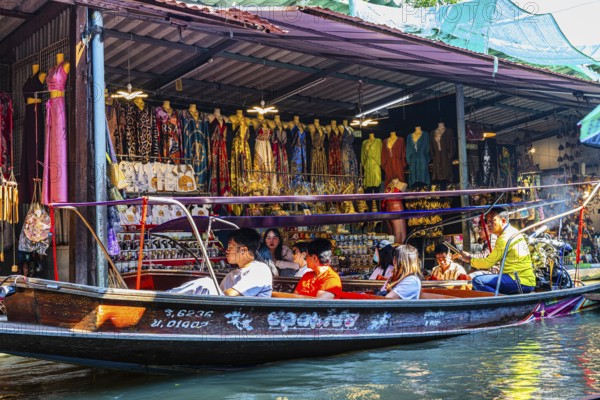Wooden boat with tourists on the Damneon Saduak floating markets channel, near Bangkok, Ratchaburi district, Thailand