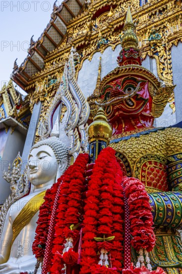 Richly decorated Buddha statue at Wat Suthiwararam Buddhist temple, guarded by a yaksha, Bangkok, Thailand's metropolis, Thailand