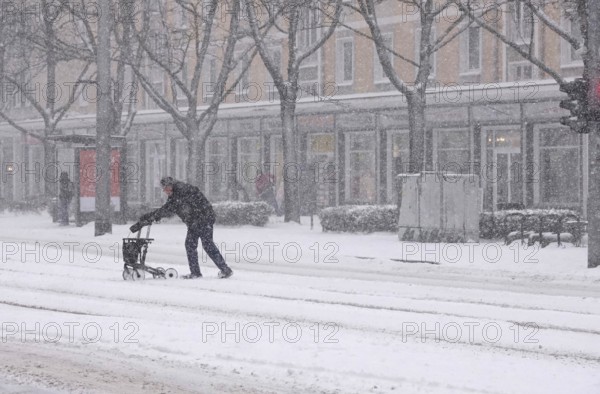 Senior with walker during heavy snowfall, winter, Germany