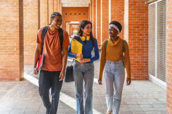 Diverse students walking through a university building on campus, carrying backpacks and notepads, smiling, and talking while enjoying their college education experience
