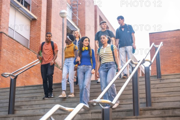 Group of diverse university students walking down outdoor stairs on campus, carrying backpacks and books, representing education, friendship, and youth