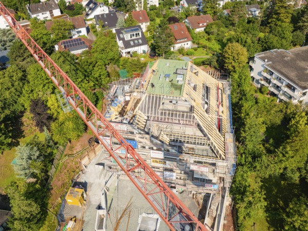 Crane over a construction site with an unfinished roof and surrounding residential buildings, carpentry construction, roof extension, renovation, Stuttgart, Germany