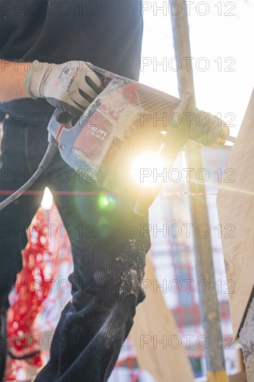 Drills and lighting effects on wood during construction work with construction workers, carpentry construction, roof extension, renovation, Stuttgart, Germany