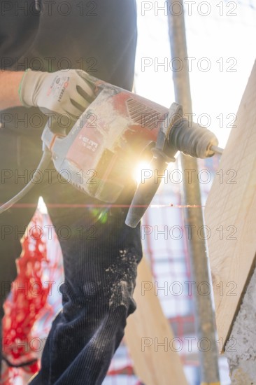 Drilling work in sunlight on construction site with wooden elements, carpentry construction, roof extension, renovation, Stuttgart, Germany