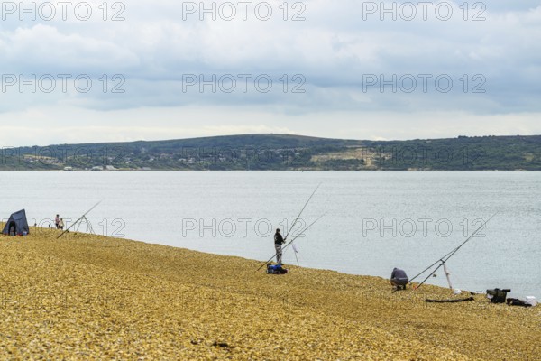 Anglers on the beach over Hurst Spit, Milford on Sea, Lymington, Hampshire, England, United Kingdom