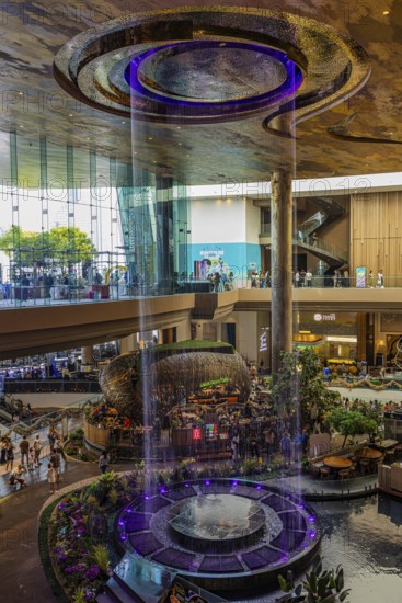 Artificial, brightly lit waterfall, magic waterfall, plunging from ceiling into a water basin, Iconsiam shopping center, Bangkok, Thailand's metropolis