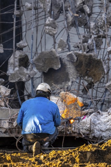 Workers with cutting torches demolishing the 120-meter long motorway bridge of the A516, across Teutoburger Straße in Oberhausen-Sterkrade, the bridge, built in 1970 was severely damaged, traffic continues to roll on the remaining west bridge, after demolition, the eastern part is rebuilt using a process that is unique in the world to date, 40 meter long precast concrete beams are assembled one after the other, reducing construction time from 24 to 7 months, After the completion of this bridge, the western part will also be rebuilt, North Rhine-Westphalia, germany