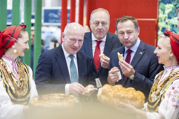 Kai Wegner (Governing Mayor of Berlin), Joachim Rukwied (President of the German Farmers' Association) and Christophe Hansen (Commissioner for Agriculture and Rural Development) at a bread tasting at the Bulgarian stand during the opening tour of the Green Week at the exhibition grounds in Berlin on 16 January 2026. The trade fair for the agricultural and food industry will take place from 16 to 25 January 2026