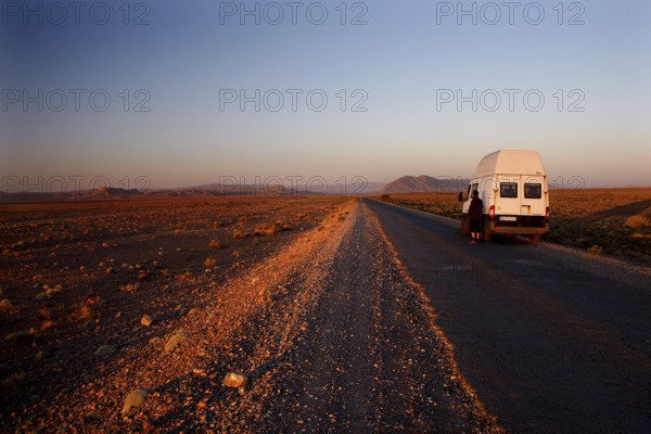 Transporter on lonely road in breathtaking evening scenery, Gourrama, Morocco