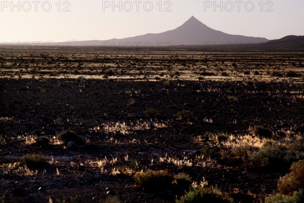 Volcano-like mountain rises from pristine desert landscape, Gourrama, Morocco