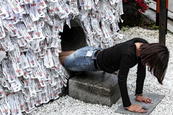 Person crawling through a ritual hole in Yasui Konpiragu Temple, Kyoto, Gion, Japan