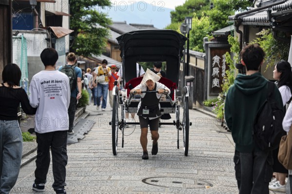 Rickshaw on busy Sannenzaka street surrounded by tourists, Kyoto, Higashiyama, Japan
